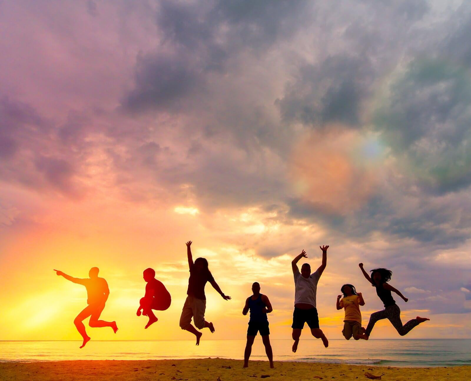 Picture of People jumping up in the air on a beach